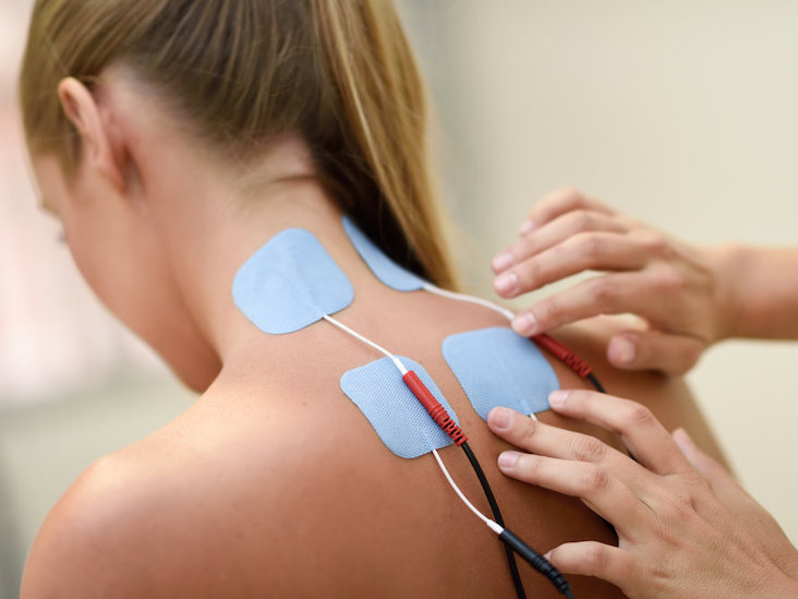 Electro stimulation in physical therapy to a young woman. Medical check at the shoulder in a physiotherapy center.